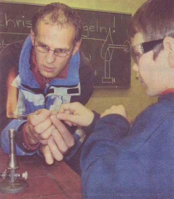 Thomas Müller hilft seinem Sohn Josia beim Herstellen einer Christbaumkugel mit dem Bunsenbrenner.